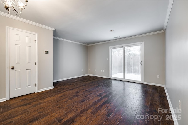 empty room featuring dark hardwood / wood-style flooring, a notable chandelier, and crown molding