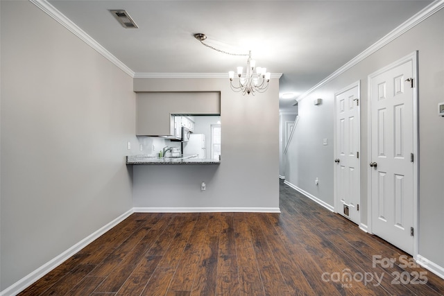 interior space with light stone countertops, ornamental molding, kitchen peninsula, and white fridge