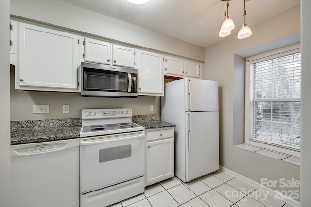 kitchen featuring hanging light fixtures, dark stone countertops, light tile patterned floors, white appliances, and white cabinets