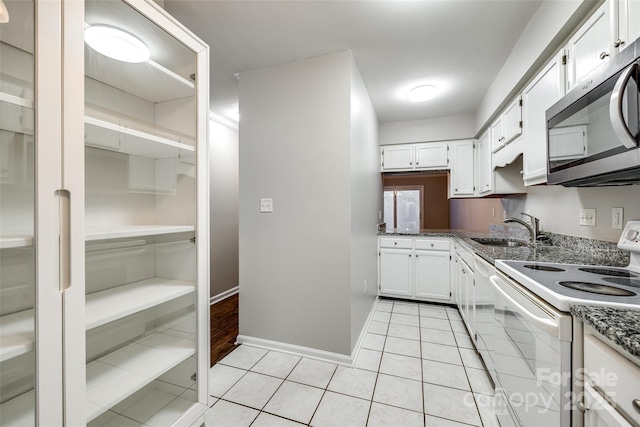 kitchen featuring white electric range oven, sink, stone countertops, light tile patterned floors, and white cabinets