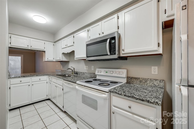 kitchen featuring sink, white appliances, white cabinetry, dark stone countertops, and light tile patterned flooring