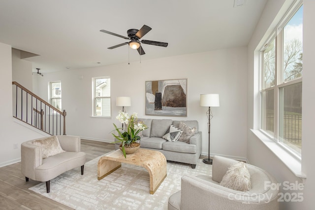 living room featuring light hardwood / wood-style flooring and ceiling fan