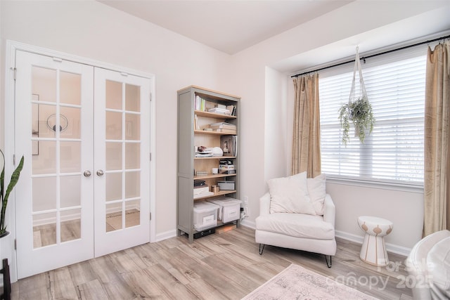 sitting room with baseboards, wood finished floors, and french doors