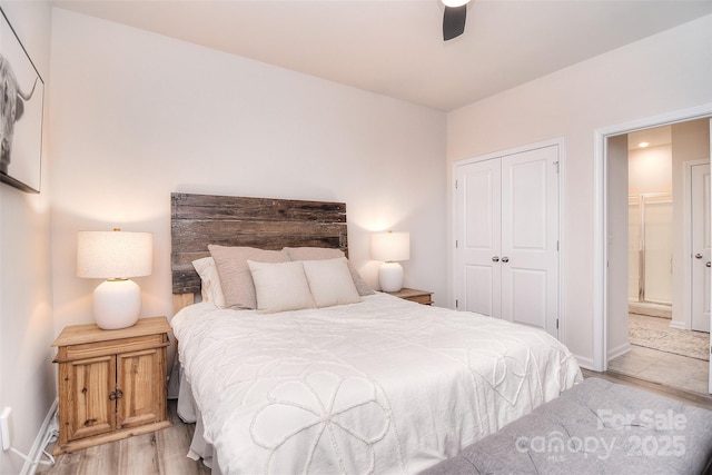 bedroom with ensuite bath, baseboards, ceiling fan, and a closet