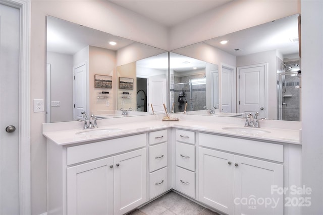 full bathroom featuring double vanity, a shower stall, a sink, and recessed lighting