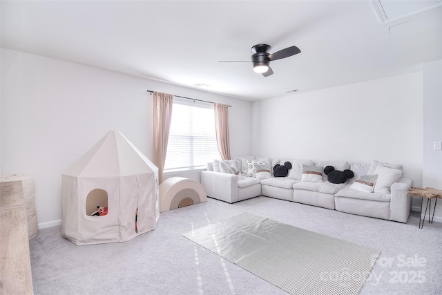 carpeted living area featuring a ceiling fan, attic access, and visible vents