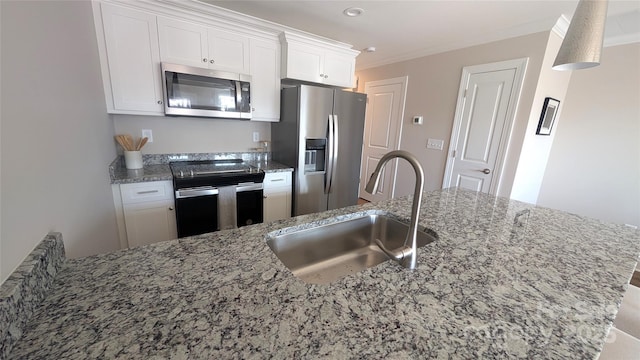 kitchen with light stone countertops, white cabinetry, appliances with stainless steel finishes, and sink