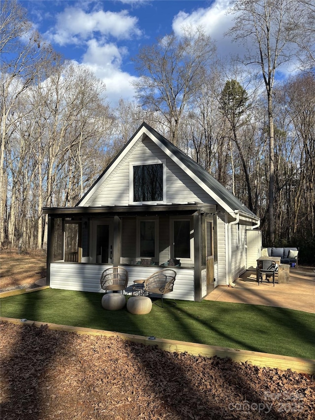 view of side of home with a yard, an outdoor hangout area, a sunroom, and a patio