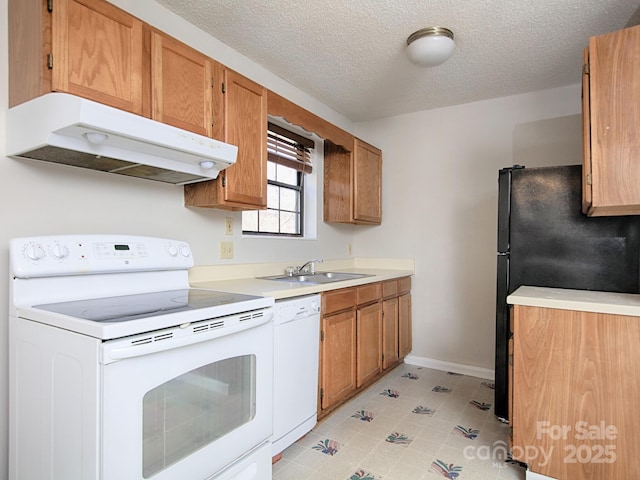 kitchen featuring white appliances, baseboards, light countertops, under cabinet range hood, and a sink