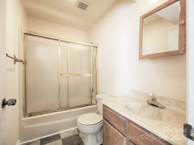 bathroom featuring toilet, combined bath / shower with glass door, vanity, and visible vents