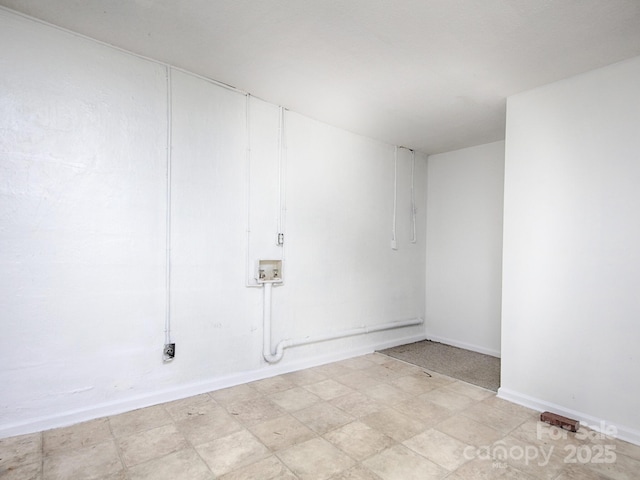 unfurnished room featuring baseboards and light floors