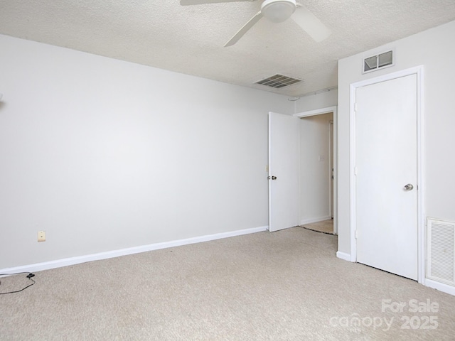 unfurnished bedroom featuring visible vents, light carpet, and a textured ceiling