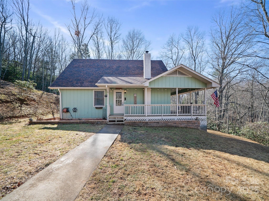 view of front of house featuring covered porch and a front yard