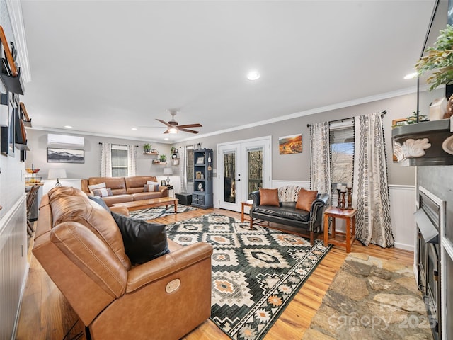 living room featuring crown molding, light hardwood / wood-style flooring, an AC wall unit, and french doors