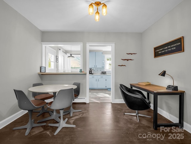 office featuring dark wood-type flooring, baseboard heating, and baseboards