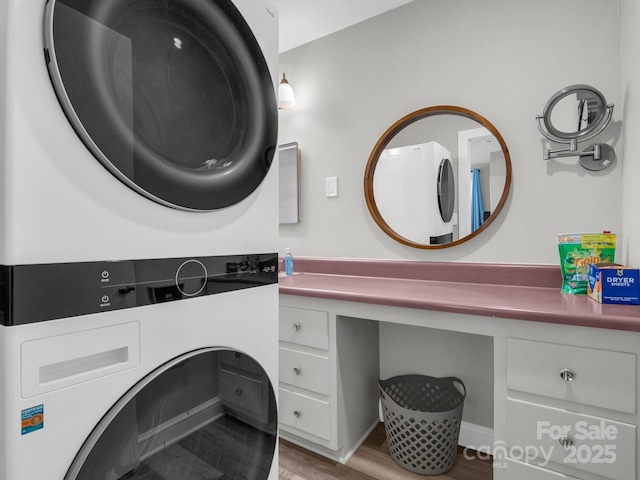 washroom with laundry area, stacked washing maching and dryer, and wood finished floors