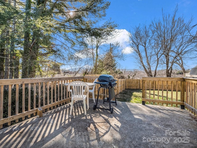 wooden terrace featuring a fenced backyard and grilling area