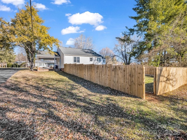 view of yard with a carport and fence