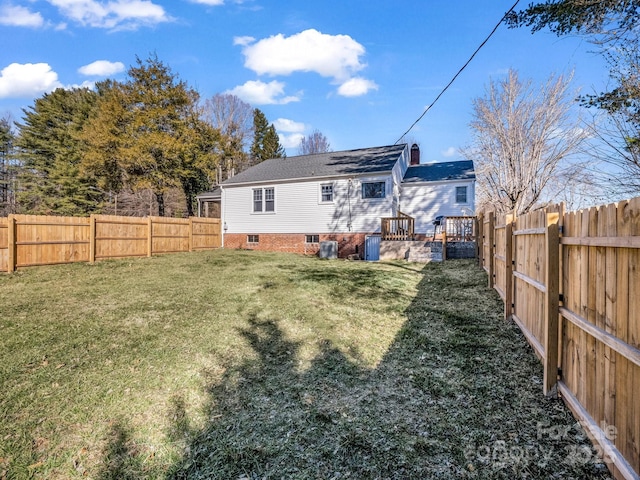 rear view of house featuring a fenced backyard and a yard