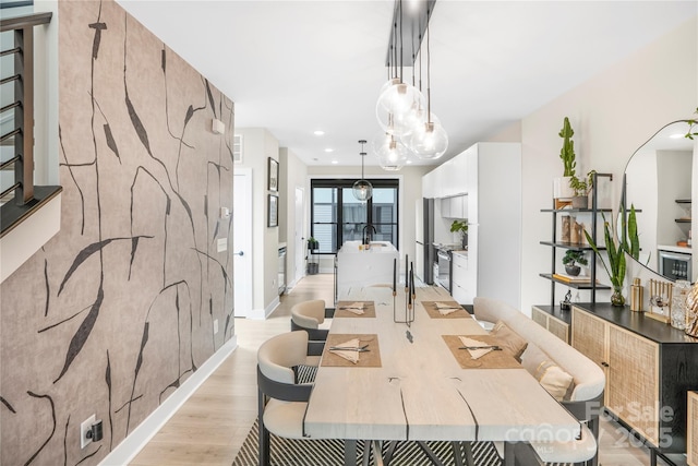 dining space featuring sink and light wood-type flooring