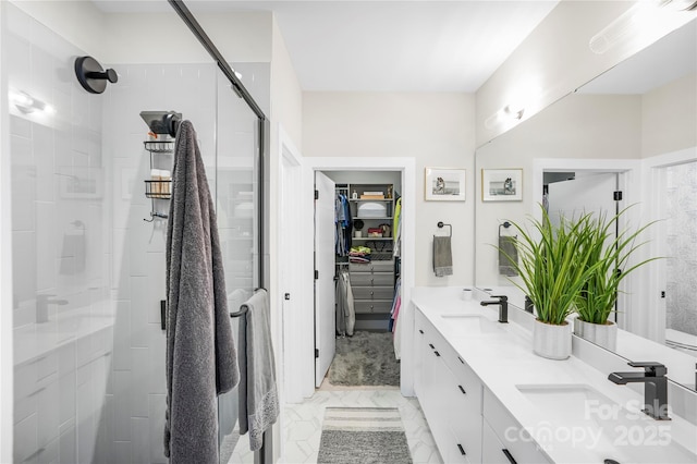 full bath with double vanity, a sink, a walk in closet, and a shower stall