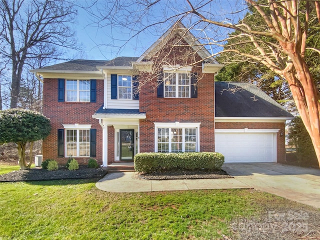 colonial home with a garage and a front lawn