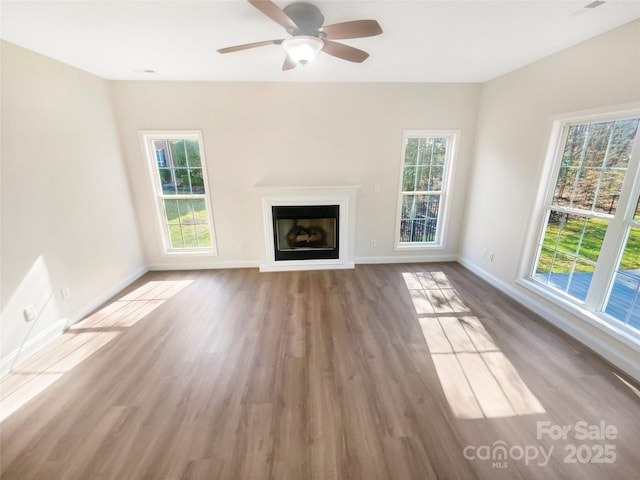 unfurnished living room featuring wood-type flooring and ceiling fan