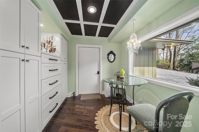 dining room featuring baseboards, dark wood finished floors, a chandelier, coffered ceiling, and recessed lighting