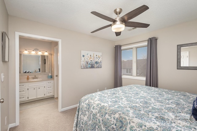 carpeted bedroom featuring sink, ceiling fan, a textured ceiling, and ensuite bathroom