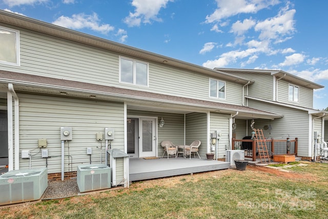 rear view of house featuring a wooden deck, a yard, and central AC unit