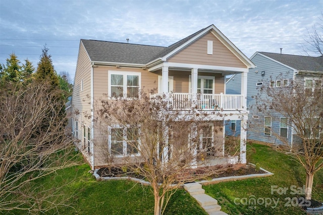 view of front of home featuring a balcony, covered porch, a front lawn, and roof with shingles