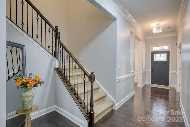 foyer featuring baseboards, ornamental molding, and dark wood-type flooring