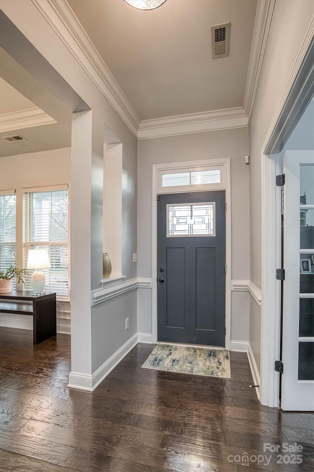 foyer featuring dark wood-style floors, baseboards, visible vents, and crown molding