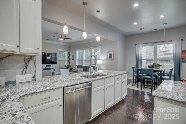 kitchen featuring a sink, white cabinetry, stainless steel dishwasher, and hanging light fixtures