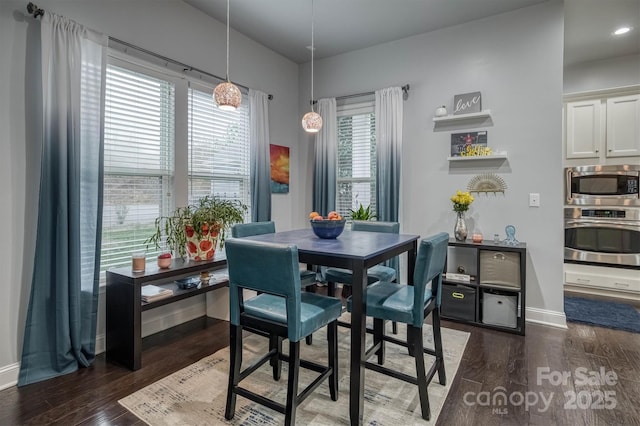 dining space with baseboards and dark wood-style flooring