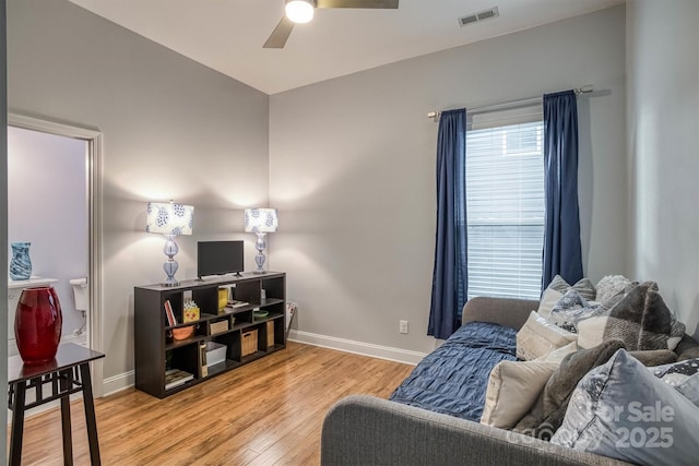 interior space featuring baseboards, visible vents, ceiling fan, and light wood finished floors