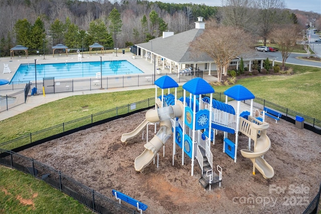 community playground with a community pool, fence, and a lawn