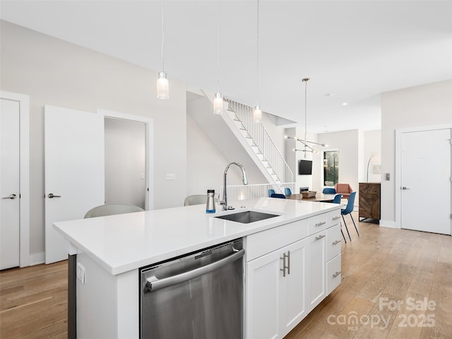 kitchen with pendant lighting, sink, white cabinetry, a center island with sink, and stainless steel dishwasher