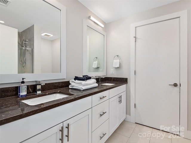 bathroom with tile patterned floors, vanity, and a tile shower