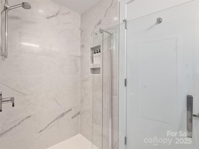 bathroom featuring a shower with shower door