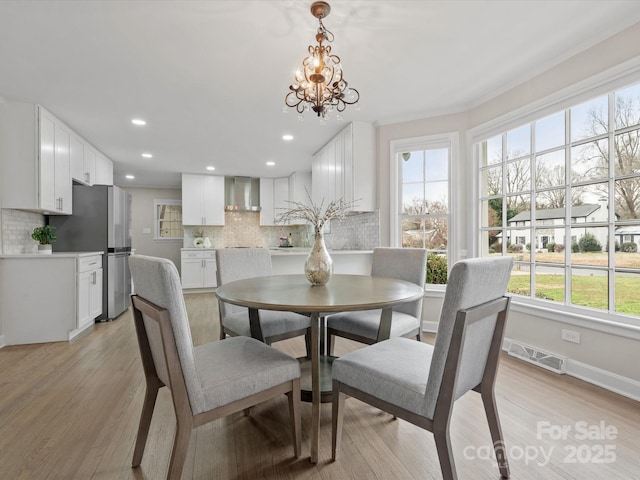 dining room featuring baseboards, visible vents, light wood-type flooring, a notable chandelier, and recessed lighting