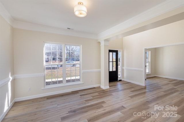 interior space featuring ornamental molding, a healthy amount of sunlight, decorative columns, and light hardwood / wood-style flooring