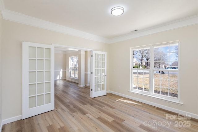 spare room featuring french doors, ornamental molding, and light hardwood / wood-style floors