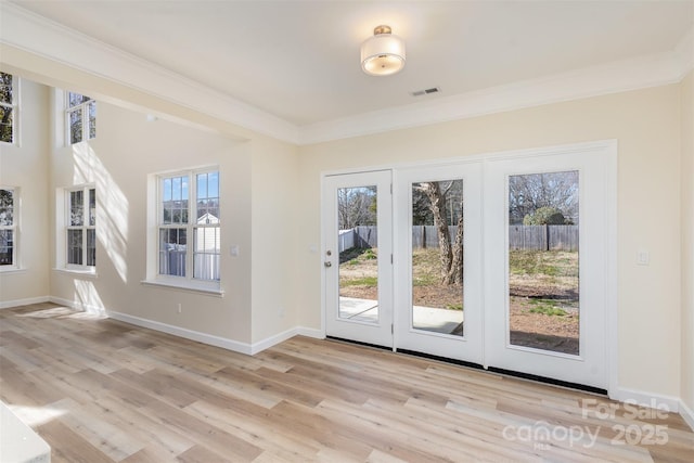 entryway featuring crown molding and light hardwood / wood-style floors