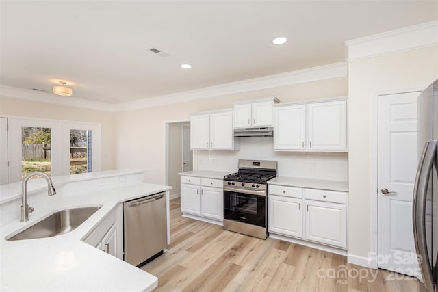 kitchen with sink, ornamental molding, white cabinets, and appliances with stainless steel finishes