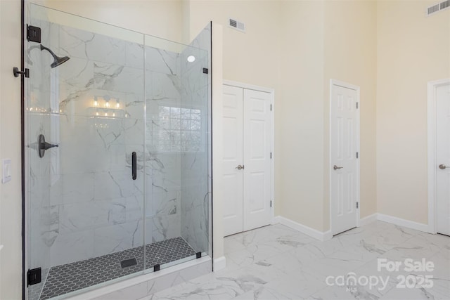 bathroom with a towering ceiling and an enclosed shower