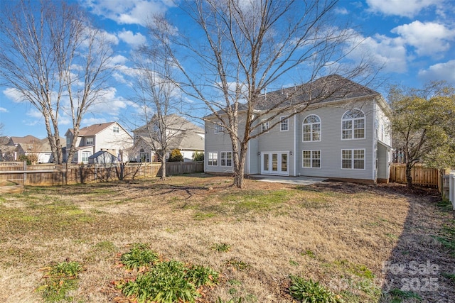 back of property with french doors, a patio, and a lawn