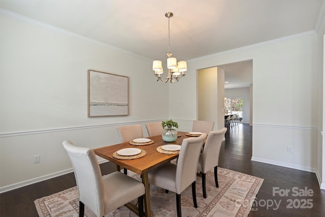 dining space with crown molding, dark wood-type flooring, and a chandelier