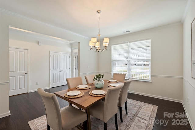 dining area featuring ornamental molding, dark wood-type flooring, and a chandelier