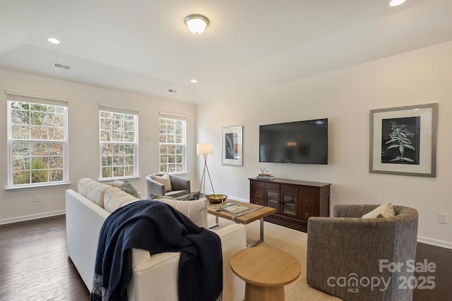 living room featuring dark wood-type flooring and a wealth of natural light